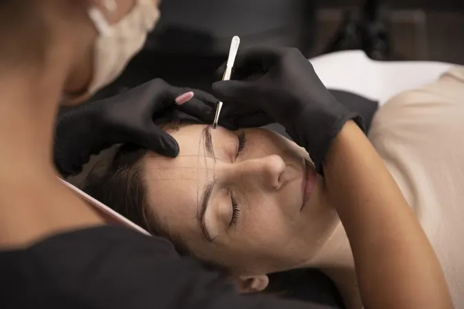 Woman Going Through Microblading Treatment X - American Academy of Micropigmentation study guide