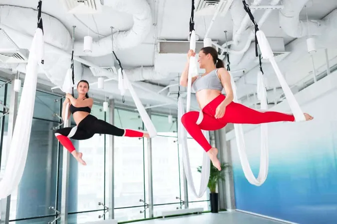 Cheerful Women Active Fit Women Wearing Leggings Top Feeling Cheerful Doing Aerial Yoga X - Aerial Fitness Certification study guide