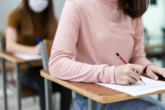 Close Up Young Female University Students Concentrate Doing Examination Classroom Girl Student Writes Answer Examinations Answer Sheet Classroom 1 1 X - Assessment of Fundamental Knowledge study guide