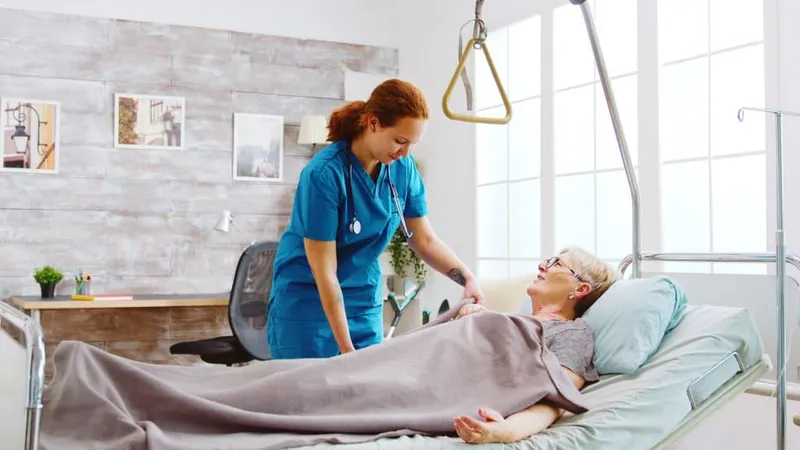 Female Nurse Helping Old Disabled Retired Woman Go Bed Caregiver Is Covering Her With Blanket X - Assisted Living Facility Administrator Certification study guide