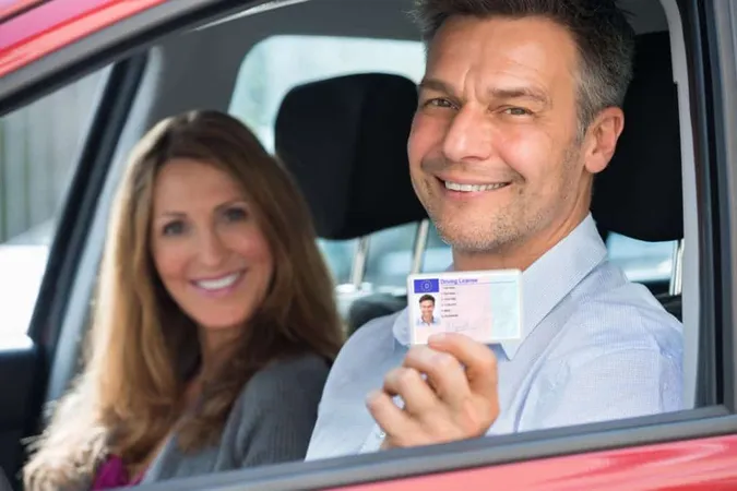 Man Sitting Inside Car Showing Driving License X - Arkansas Department of Motor Vehicle study guide