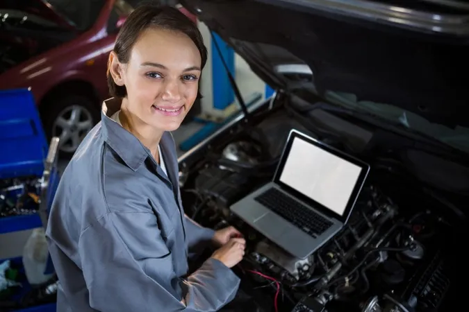 Female Mechanic Examining Car Engine With Help Laptop X - Audi Certified Mechanic study guide