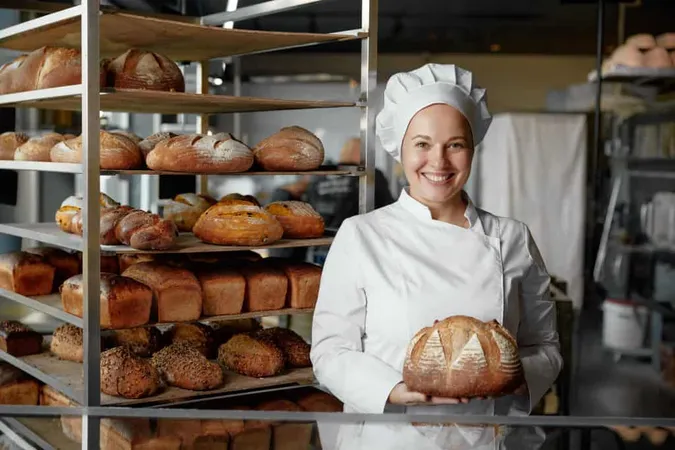Happy Woman Baker Chef Holding Bread Standing Near Showcases X - Certified Artisan Baker study guide