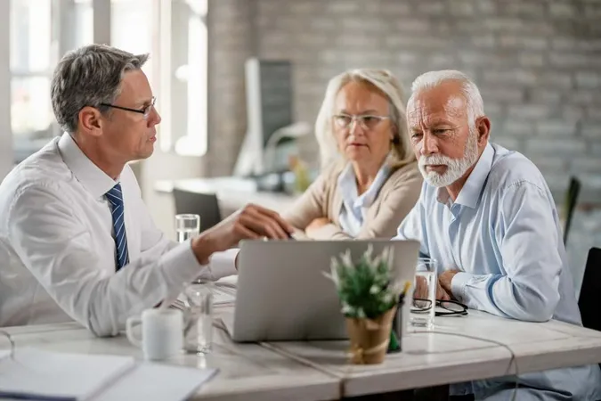 Mature Couple Their Bank Manager Using Computer While Having Consultations Office X - Certified Aging-in-Place Specialist study guide