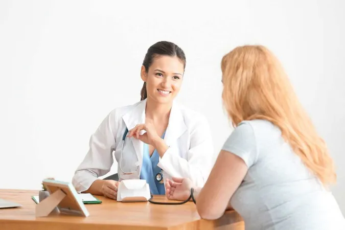 Young Female Doctor Measuring Blood Pressure Overweight Woman Clinic X - Certified Bariatric Nurse study guide