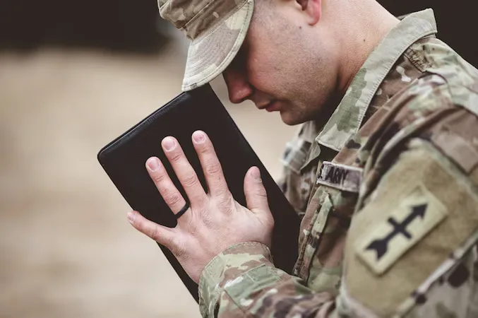 Shallow Focus Shot Young Soldier Praying While Holding Bible - Certified Chaplain Assistant study guide