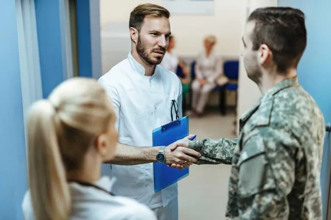 Young Doctor Talking Soldier While Greeting Him Lobby Clinic X - Certified Correctional Health Professional study guide