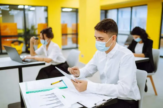 Office Worker Wearing Face Mask Social Distancing Virus Prevention While Using Laptop X - Certified Defense All-Source Analysis study guide