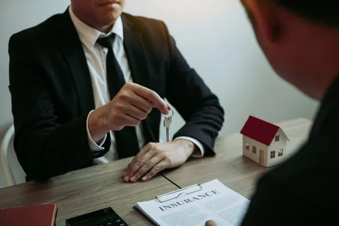 Midsection Real Estate Agent Holding Key By Client With Insurance Paper Table X - Certified Estate and Trust Specialist study guide