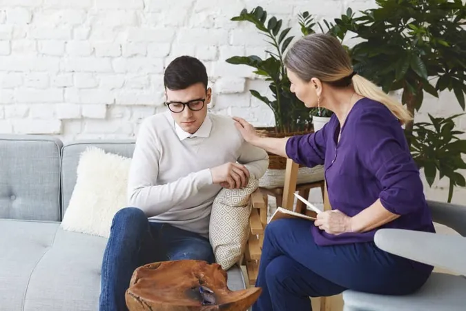 Candid Shot Casually Dressed Professional Woman Psychotherapist Her Fifties Touching Her Young Male Patient By Shoulder While Having Counseling Session Exp X - Crisis Intervention Counselor study guide