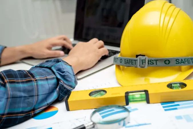 Asian Engineer With Architectural House Plan Project Blueprint Graph Yellow Helmet Engineering Construction Tools X - Construction Industry Training Board study guide