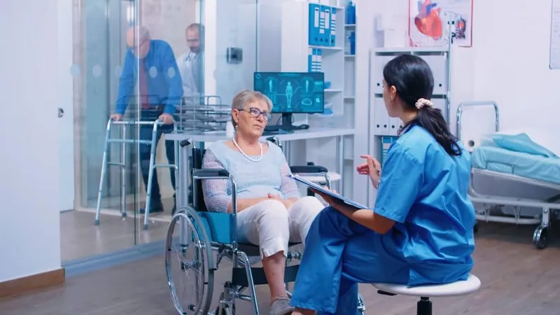 Nurse Talking With Senior Woman With Walking Disabilities Sitting Wheelchair Into Private Modern Recovery Clinic Hospital Handicapped Old Retired Patient Medical Consultation Advi X - Certified Medical Aide study guide