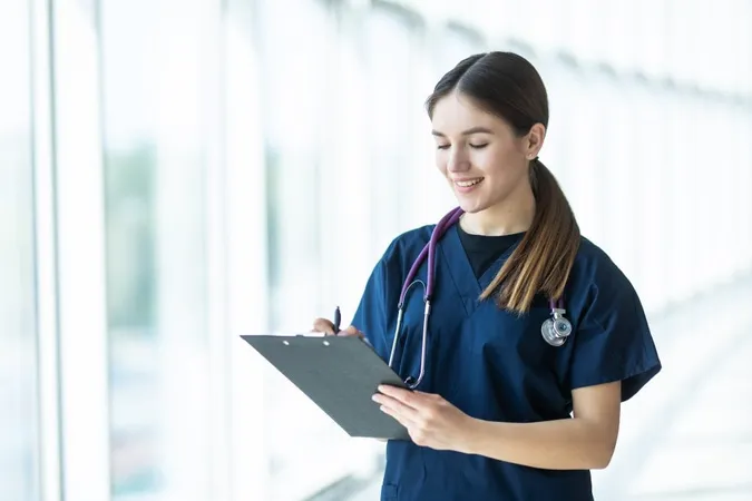Smiling Young Female Doctor Holding Clipboard Hospital X - Certified Medical Manager study guide