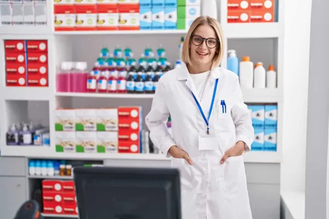 Young Blonde Woman Pharmacist Smiling Confident Standing Pharmacy X - Certified Specialty Pharmacist study guide