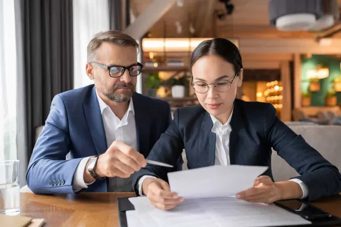 Confident Businessman Pointing Contract While His Female Colleague Reading Its Terms Points Meeting Restaurant X - Certified Tax Coach study guide