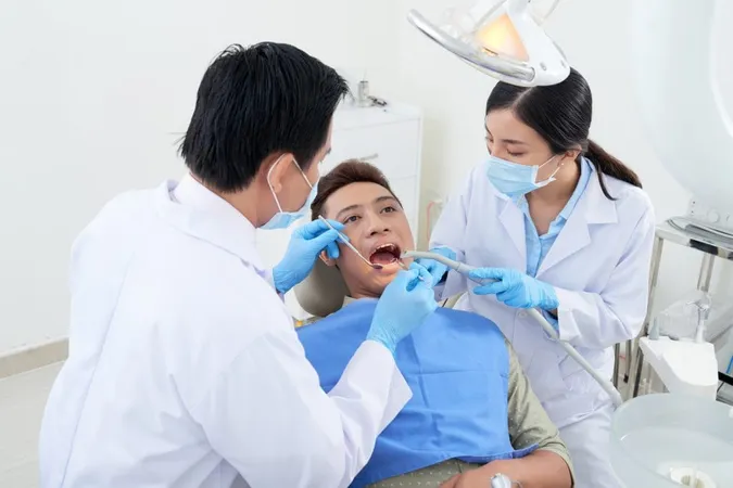 Male Dentist Nurse Examining Asian Patient S Teeth Clinic X - DANB General Chairside Assisting (GC) Test study guide