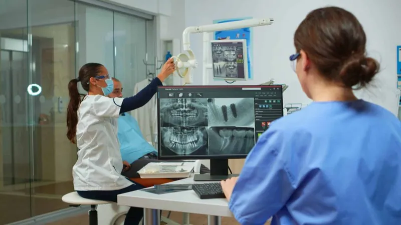 Nurse Analysing Digital X Ray Sitting Front Pc Stomatologic Clinic While Doctor With Face Mask Is Working With Patient Background Examining Teeth Problems Lighting Lamp X - Dental Radiology Certification for Dental Hygienist study guide