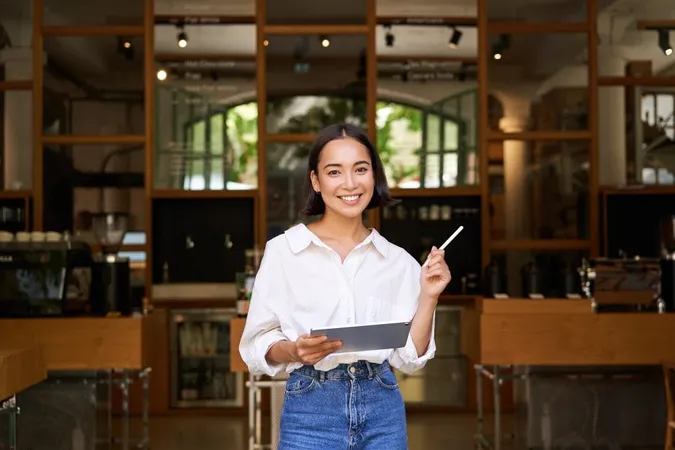 Portrait Asian Woman Manager Standing With Tablet Front Cafe Entrance Welcomes Guests X - Event Manager Certification study guide