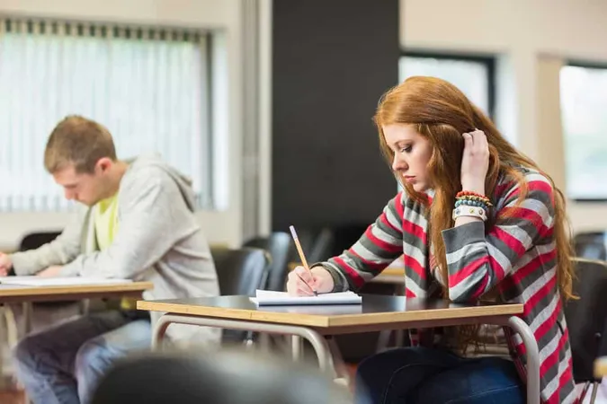 Semale Student With Others Writi - GED study guide