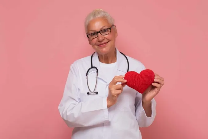 Happy Smiling Senior Female Doctor Holding Red Heart Isolated Pink Background X - International Board of Heart Rhythm Examiners study guide