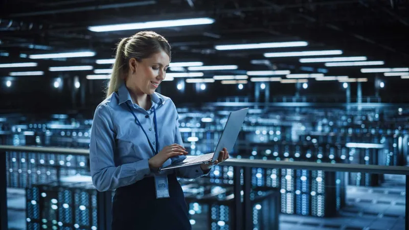 Portrait It Specialist Using Laptop Data Center Big Server Farm Cloud Computing Facility With Female System Administrator Monitoring Cyber Security Network Protection Services - Informatica Cloud Certification study guide