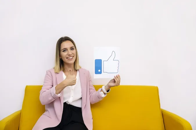 Young Woman Sitting Yellow Sofa Holding Like Icon Showing Thumbup Sign X - Medallia Customer Experience Certification study guide