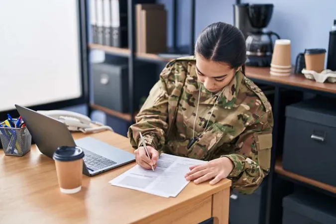 Young Hispanic Woman Army Soldier Using Laptop Writing Document Office X - Military Relocation Professional study guide