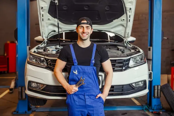 Mechanic Man Uniform Holding Wrenches Auto Service Center Smiling Camera 1 X - National Automotive Parts Association Certified Mechanic study guide