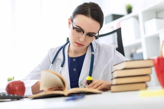Beautiful Young Girl White Robe Is Sitting Computer Desk With Marker Book Photograph With Depth Sharpness Highlighted Focus Girl X - National Certified Medical Assistant study guide