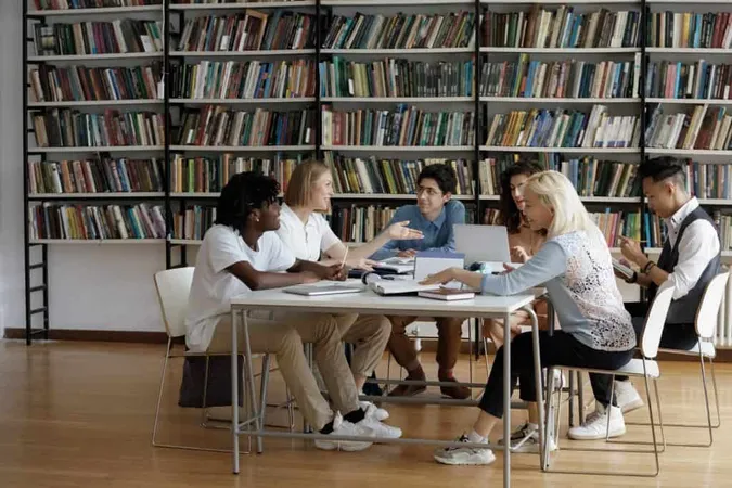 Happy Busy Multiethnic Group Students Discussing Study Project University Library Talking Laughing Table With Laptops Open Books Cooperating Research Together Education Concept X - New Jersey Bar Exam study guide