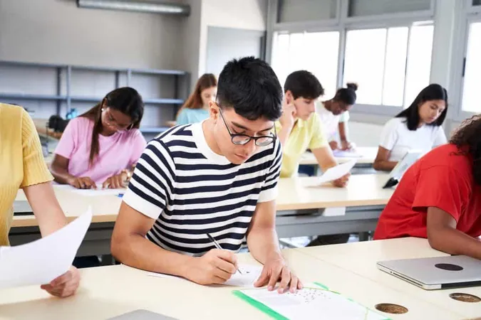 Student Taking Notes While Studying High School Satisfied Young Man While Sitting Desk Classroom Portrait College Guy Writing While Completing Assignment X - Ohio Department of Education study guide
