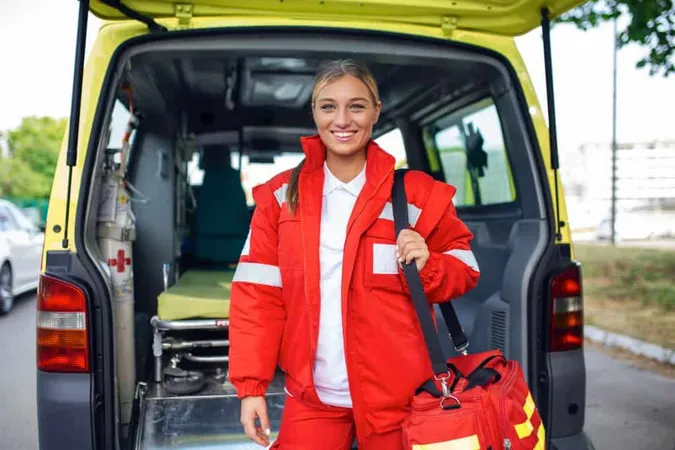 Young Woman Paramedic Standing Rear Ambulance By Open Doors She Is Looking Camera With Confident Expression Smiling Carrying Medical Trauma Bag Her Shoulder X - Red Cross Instructor Certification study guide