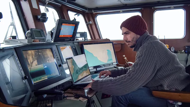 Man Is Working Computer Boat With Map Ocean - Vessel Traffic Services Operator Exam study guide